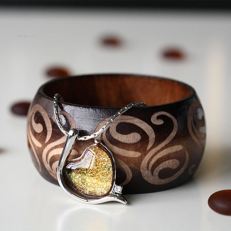 Elegante braccialetto color argento intarsiato con pendente in vetro